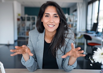 Woman in black and gray business attire gesturing with hands