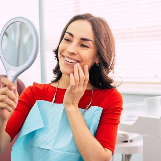 a patient checking her smile with a mirror