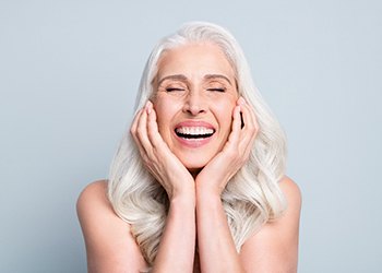 A pretty gray-haired lady enjoying her dental implants