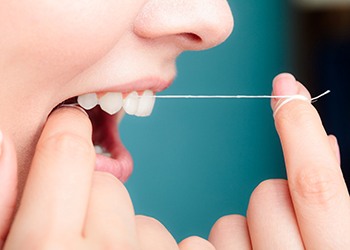 Woman flossing her teeth